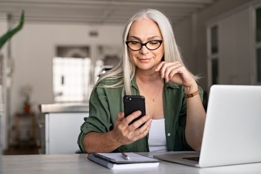 Woman using a computer and phone.