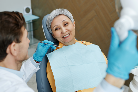 Dentist with smiling adult patient.