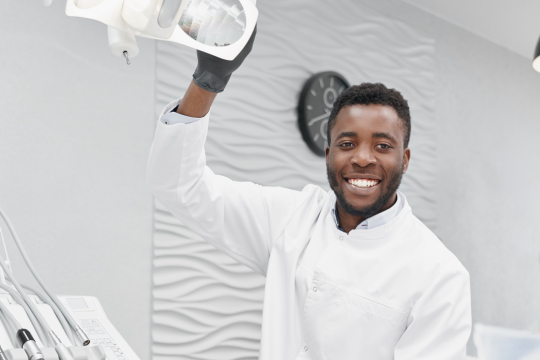 Homme adulte dentiste en uniforme blanc.